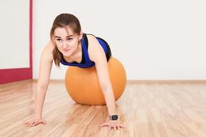 jung Frau ist Ausbildung durch tun drücken oben mit Übung Ball im Fitnessstudio foto