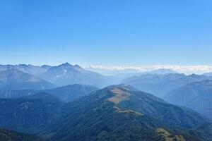 Aussicht von das oben von montieren oshten zu das Grate von das Kaukasus Berge im ein Blau Dunst foto