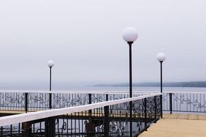 nebelig Seebrücke mit Laternen foto