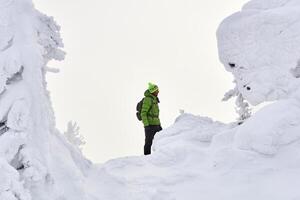 Mann Reisender im Winter Berge während ein Schneesturm foto