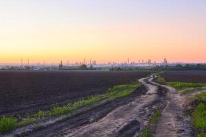 Abend ländlich Landschaft mit ein enorm Öl Raffinerie auf das Horizont foto