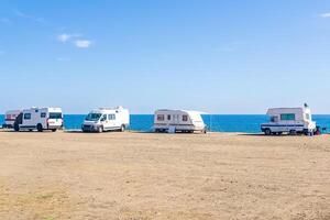Campingplatz mit geparkt Anhänger durch das Meer foto