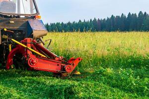 Traktor mit ein montiert Mäher mäht Wiese forbs foto