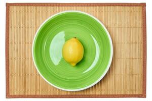 Gelb Zitrone auf ein Grün Teller auf ein Stock Platz Matte foto
