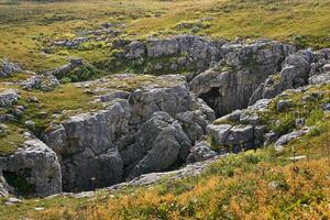 Karst Loch im das Mitte von das Herbst alpin Wiese foto