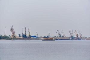 industriell Fluss Wasserlandschaft mit Bauholz Ladung Schiff und Ladung Terminal foto