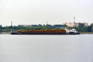 Fluss Bauholz Träger Schiff geladen mit Protokolle bewegt sich Vergangenheit das städtisch Küste foto