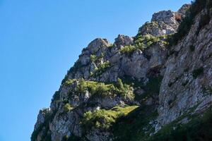 steil Berg Klippen, bewachsen mit Vegetation, gegen das Himmel foto