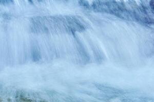 natürlich Hintergrund - - das Jets von das Wasserfall sind verschwommen im Bewegung foto