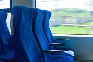 Innere von Pendler Passagier Zug Auto, Reihe von Stühle und ein Bewegungsunschärfe Landschaft draußen das Fenster foto