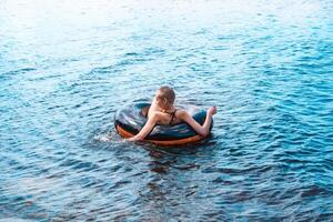 Teen Mädchen Schwimmen mit ein schwimmen Tube foto