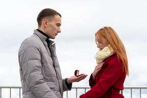 jung Mann macht ein Ehe Vorschlag zu ein Mädchen, die Geschenke ein Ring foto