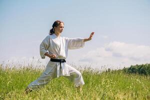 Teen Mädchen Ausbildung Karate Kata draußen foto