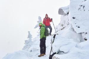 zwei männlich Reisende im Winter Berge während ein Schneesturm foto