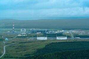 Antenne Aussicht von Pflanze zum das Produktion von verflüssigt natürlich Gas im ein natürlich Bereich gegen das Hintergrund von Berge foto