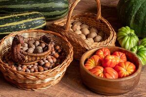 Ernte von frisch Tomaten, Kürbis und Zucchini und Körbe mit Haselnüsse und Walnüsse gestapelt auf das Fußboden foto