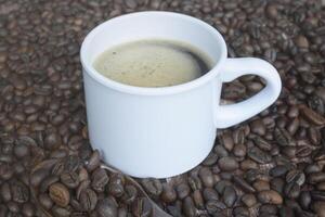 frisch geröstet Kaffee Bohne Hintergrund mit ein Tasse von heiß Espresso. foto