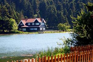 Haus auf das Ufer von See. reflektiert auf Wasser. Land Seite, Wald, Bauernhof Feld, See mit Haus. Bolu, Türkei foto