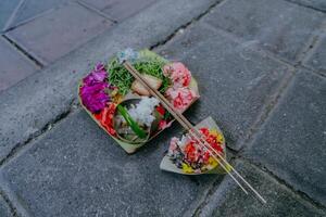 kann Sari, balinesisch Angebote auf ein Stein Mauer. klein Religionen Angebot gemacht aus von Blumen. traditionell Täglich im bali Angebote. foto