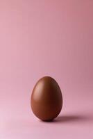 ai generiert einer Schokolade Ei auf Pastell- Rosa Hintergrund foto