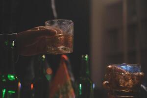 Feier Nacht, gießen Whiskey in ein Glas. geben zu freunde Wer Kommen Sie zu feiern foto