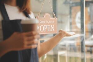 Startup erfolgreicher Kleinunternehmer SME Schönheitsmädchen steht mit Tablet-Smartphone im Café-Restaurant. Porträt der Barista-Café-Besitzerin mit asiatischer Bräune. KMU-Unternehmer-Verkäufer-Geschäftskonzept foto