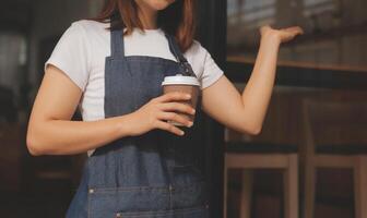 Startup erfolgreicher Kleinunternehmer SME Schönheitsmädchen steht mit Tablet-Smartphone im Café-Restaurant. Porträt der Barista-Café-Besitzerin mit asiatischer Bräune. KMU-Unternehmer-Verkäufer-Geschäftskonzept foto