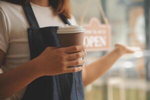 Startup erfolgreicher Kleinunternehmer SME Schönheitsmädchen steht mit Tablet-Smartphone im Café-Restaurant. Porträt der Barista-Café-Besitzerin mit asiatischer Bräune. KMU-Unternehmer-Verkäufer-Geschäftskonzept foto