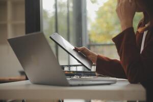 Schuss von ein asiatisch jung Geschäft weiblich Arbeiten auf Laptop im ihr Arbeitsplatz. foto