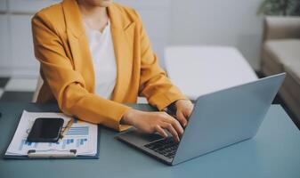 glücklich tausendjährig kaukasisch Dame im passen Tippen auf Tablette beim Arbeitsplatz mit Laptop im Licht Büro Innere. Manager arbeiten, Geschäft mit Gerät, Anwendung, Plaudern mit Klient entfernt foto