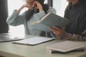 asiatisch Geschäftsfrau Arbeiten auf Laptop Computer aussehen zum Job online, freiberuflich suchen und Tippen auf Notizbuch auf Tisch, Lebensstil von Frau studieren online foto