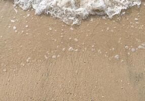 Weiß Blase von Meer Welle auf fein Sand beim das Strand foto