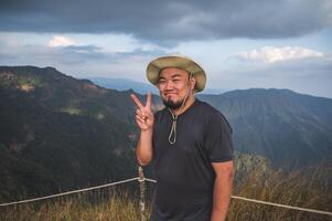 asiatisch Fett Mann mit schön Aussicht von khao san nein Wu Berg kanchanaburi.khao san nein Wu ist das höchste Berg im khao laem National Park. es ist 1767 Meter über Meer eben. foto