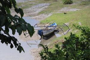 hölzern Boot auf das Fluss Kante foto