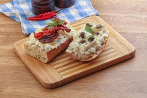 Bruschetta mit Weichkäse, Kapern und Tomate foto