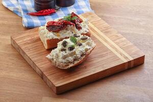 Bruschetta mit Weichkäse, Kapern und Tomate foto