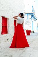 Ferien Stimmung. Brünette Frau im rot Sommer- Kleid foto