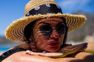 Frau im Bikini und Stroh Hut Lügen auf tropisch Strand foto