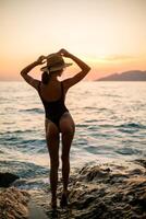 jung Mädchen schwarz Badeanzug auf das Sonnenuntergang foto