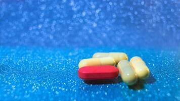 Tabletten oder Kapseln auf Blau Hintergrund mit Kopieren Raum. Droge Rezept zum Behandlung Medikation foto