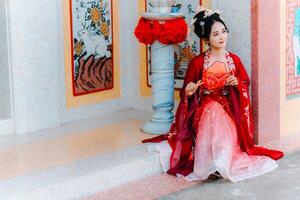 Frau Kleid China Neu Jahr. Porträt von ein Frau. Person im traditionell Kostüm. Frau im traditionell Kostüm. schön jung Frau im ein hell rot Kleid und ein Krone von Chinesisch Königin posieren. foto