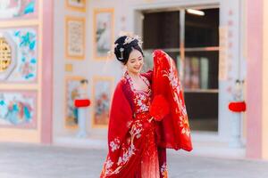 Frau Kleid China Neu Jahr. Porträt von ein Frau. Person im traditionell Kostüm. Frau im traditionell Kostüm. schön jung Frau im ein hell rot Kleid und ein Krone von Chinesisch Königin posieren. foto