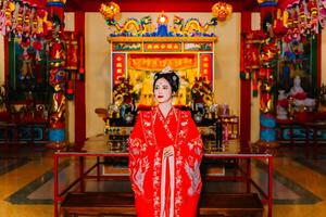 Frau Kleid China Neu Jahr. Porträt von ein Frau. Person im traditionell Kostüm. Frau im traditionell Kostüm. schön jung Frau im ein hell rot Kleid und ein Krone von Chinesisch Königin posieren. foto
