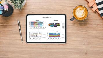 Geschäft Analytik Konzept, ein gut organisiert Arbeit Raum mit ein Tablette präsentieren ein detailliert Zusammenfassung Bericht, begleitet durch ein Tasse von Latté und Büro liefert auf ein hölzern Schreibtisch. foto