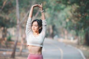 Fitness Konzept, passen jung Frau tun ein Dehnen Routine im ein Park, bleiben gesund mit draussen Übung. foto
