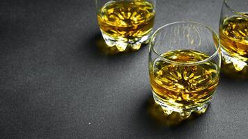 Whiskey im ein Glas. drei Brille von Whiskey oder Bourbon auf ein dunkel Tisch. stark alkoholisch Getränke. foto