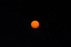 Orange Sonne im das dunkel Himmel. foto