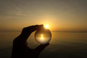Kristall im Hand beim Sonnenuntergang. foto