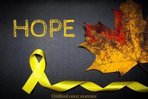 hoffen Kindheit Krebs Bewusstsein Tag. Gelb Band auf schwarz Hintergrund. foto