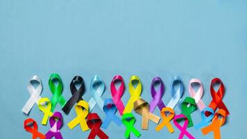 Welt Krebs Tag. bunt Bänder, Krebs Bewusstsein, Blau Hintergrund. International Agentur zum Forschung auf Krebs foto